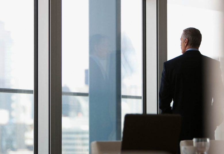 Corporate businessman in a boardroom looking out the window