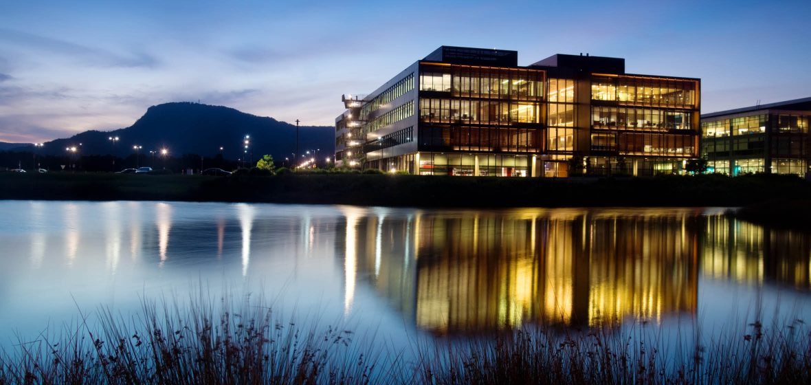 View of several office buildings across a lake, at dusk