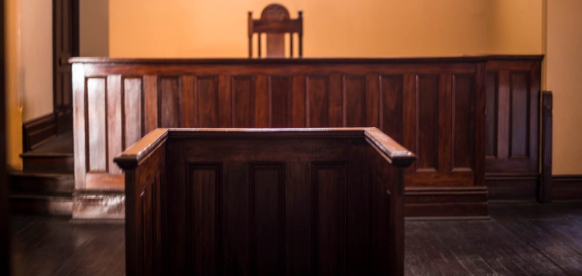 An empty witness box faces an empty court bench