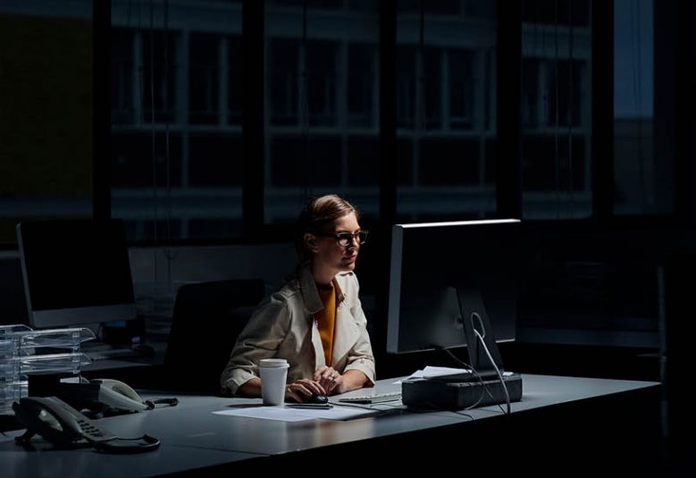woman using a computer in a dark office