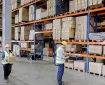 staff move boxes in a warehouse