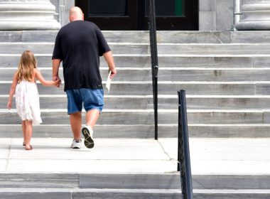 Man and child walking up courthouse steps
