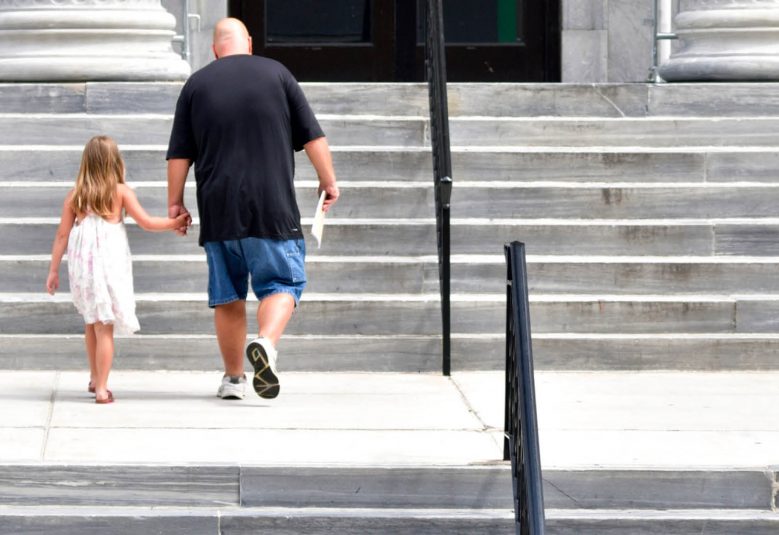 Man and child walking up courthouse steps