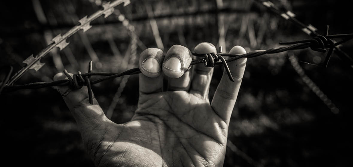 Hands holding wire fence