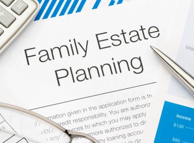 A family estate planning document on a desk with a calculator, pen and eyeglasses