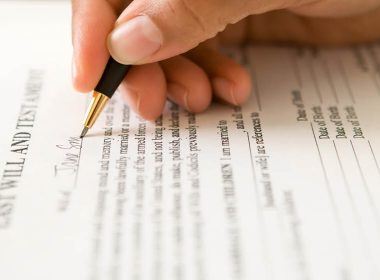 Image of hand signing a will
