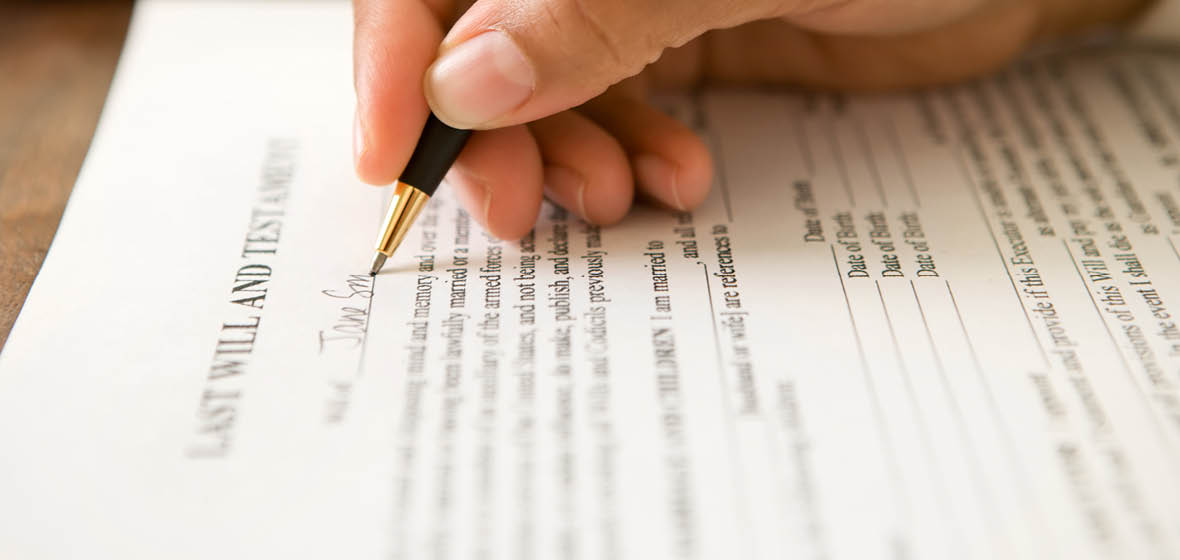 Image of hand signing a will