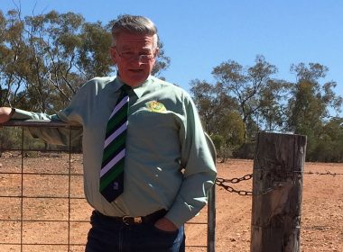 Cobar solicitor and conveyancer Peter Payne standing in front of a barbed wired fence in regional NSW.
