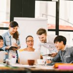 Colleagues discuss ideas while looking at a laptop