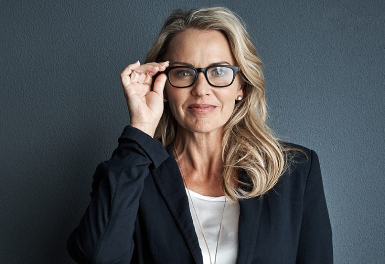Professional woman holding reading glasses
