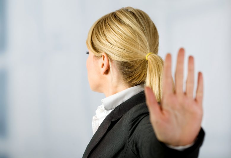 Businesswoman holding her palm out indicating Stop