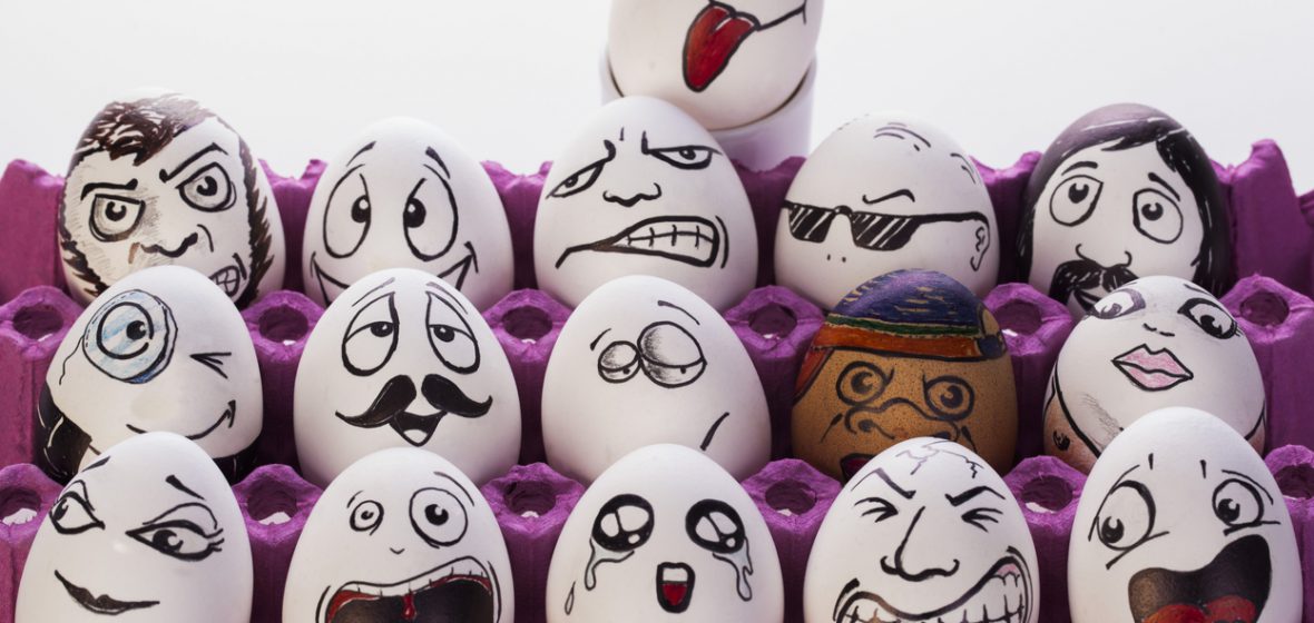 Carton of eggs with funny faces drawn on them