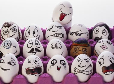 Carton of eggs with funny faces drawn on them