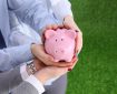 Two people holding a piggy bank