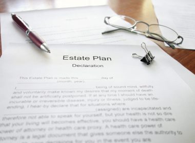 An Estate Plan document on a desk with pen and glasses
