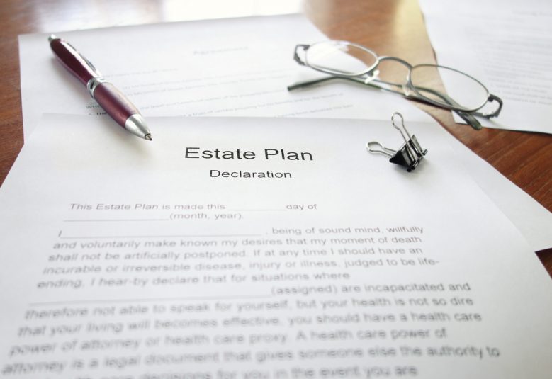 An Estate Plan document on a desk with pen and glasses