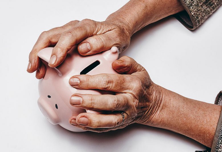 Older woman holds a piggy bank