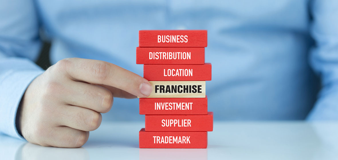 Blocks of wood with words business, distribution, location, franchise, investment, supplier, trademark on the sides