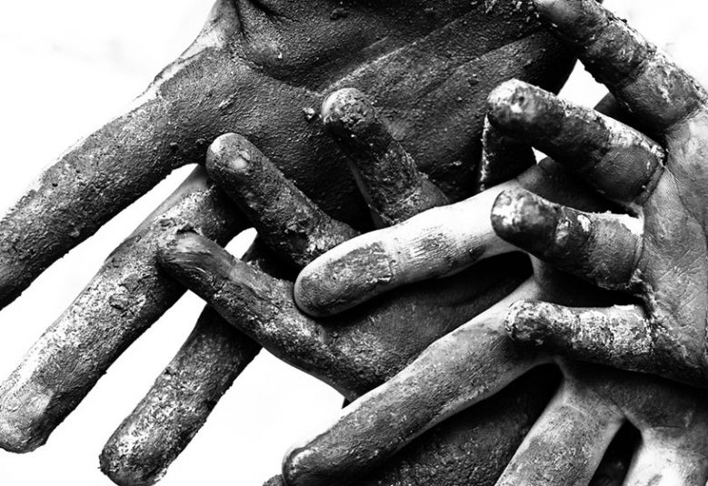 Closeup of adult and child hands covered in dust