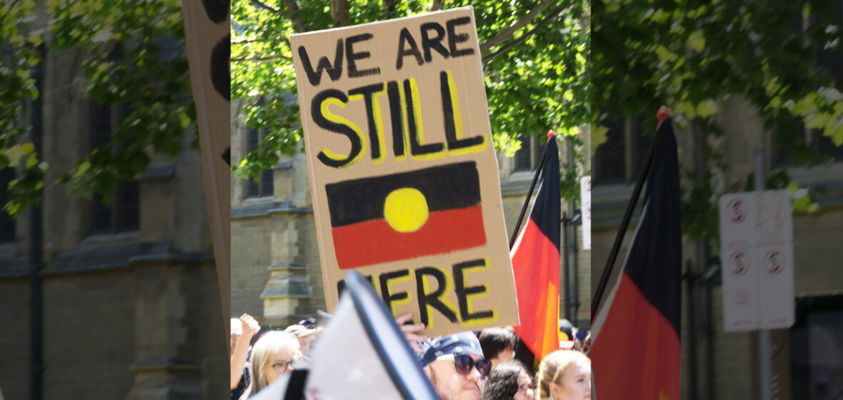 crowd holding poster calling for Indigenous constitutional recognition