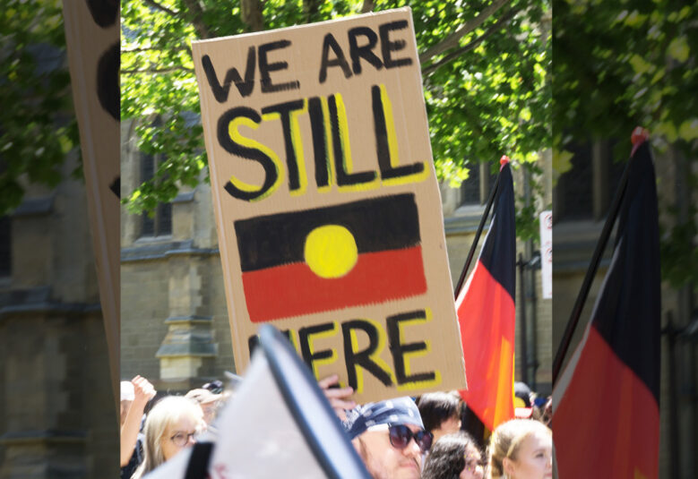 crowd holding poster calling for Indigenous constitutional recognition