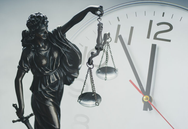 photo of sclaes of justice and clock to illustrate delays in coronial system