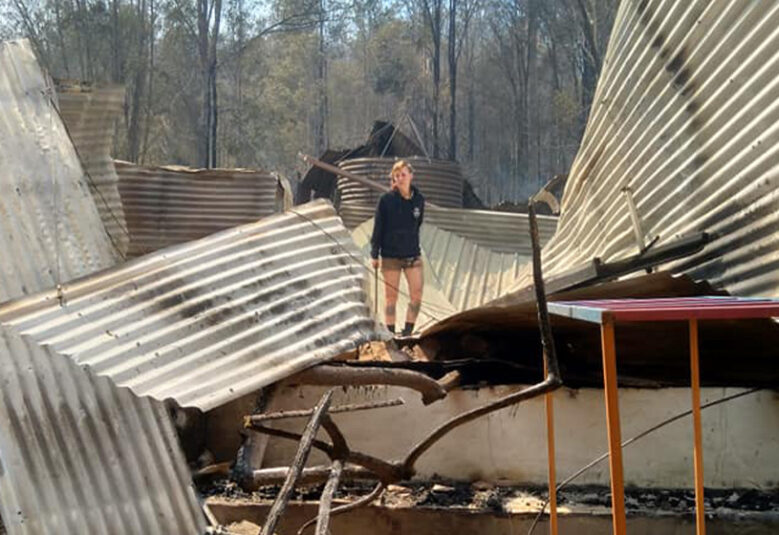[image] photo of bushfire survivor with burned house
